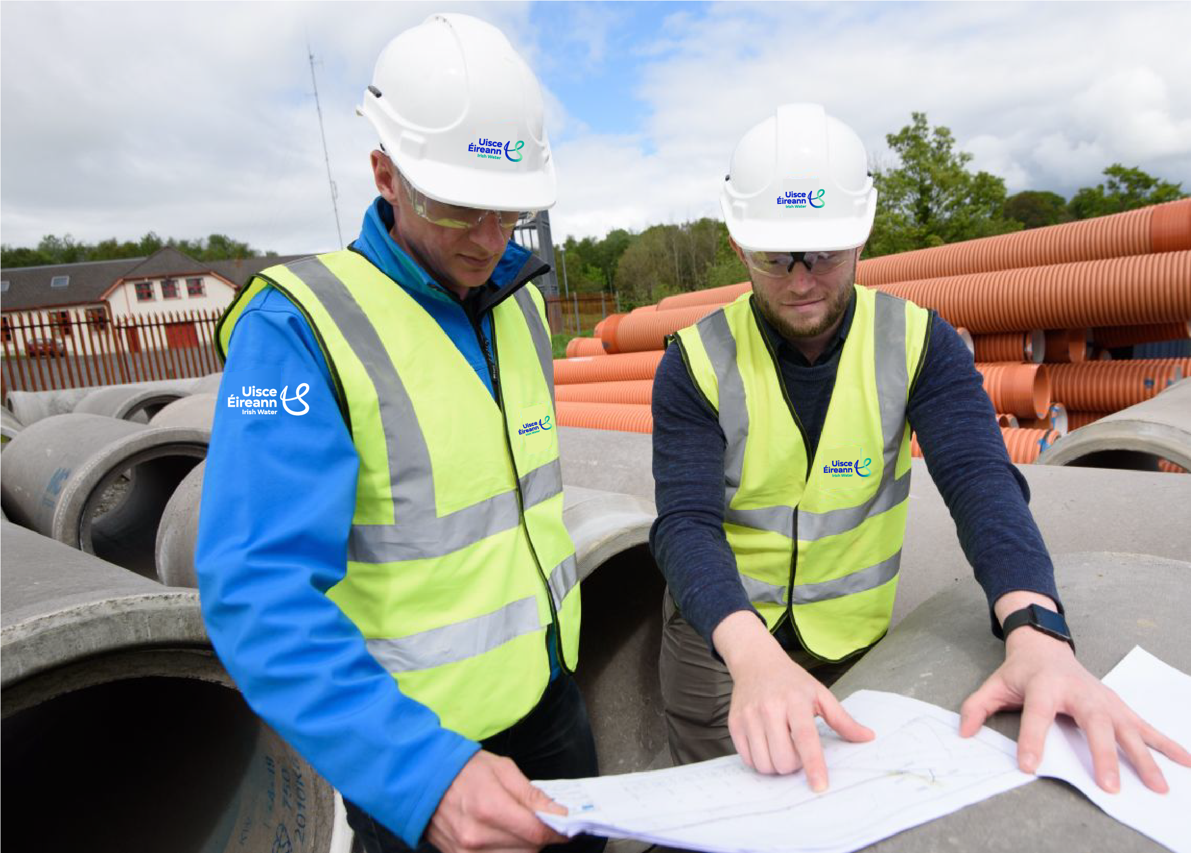 Two Uisce Éireann workers looking at plans on a site