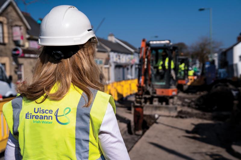 An Uisce Éireann worker on a site with a digger