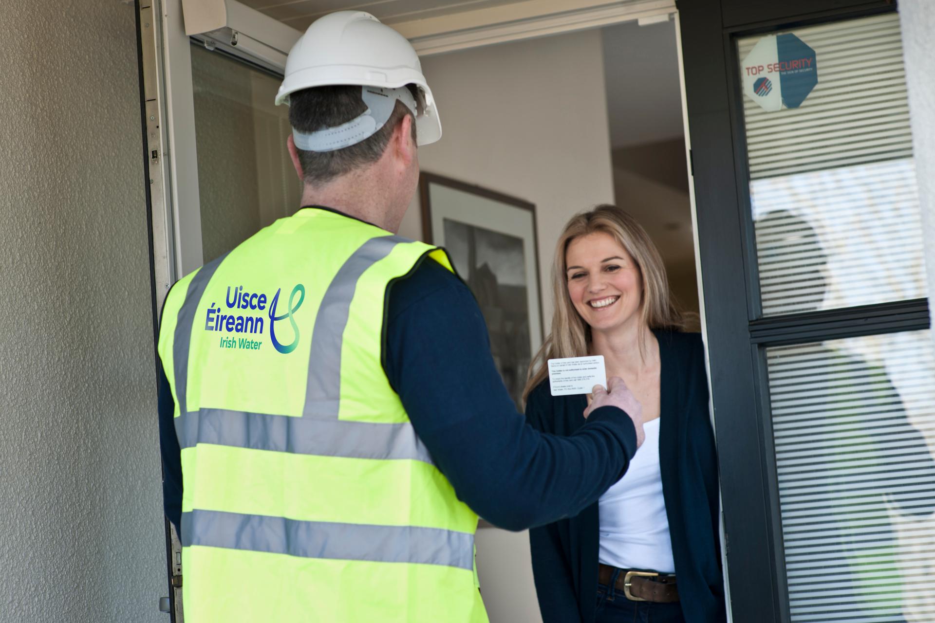 a woman at the door talking to a uisce eireann contractor 