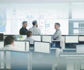 Three Uisce Éireann workers discussing data projected on the wall in an office