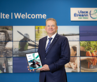 A minister holding the 2023 Annual Report for Uisce Éireann