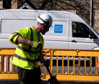 An Uisce Éireann worker with a shovel on a construction site
