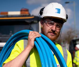 Uisce Éireann worker with blue pipes slung over his shoulder 
