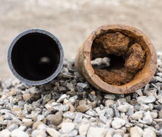 A new pipe next to an old and rusty pipe