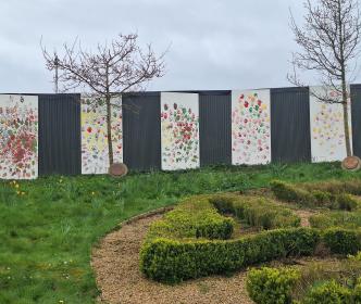 A garden with a wall of handprint paintings