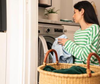 A woman putting clothes in a washing machine