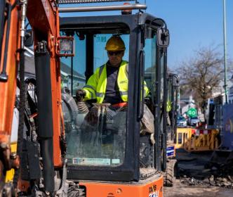 An Uisce Éireann worker in a digger on a site