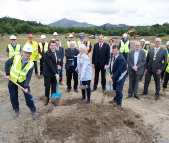A group of Uisce Éireann workers and other people on a site, some with shovels
