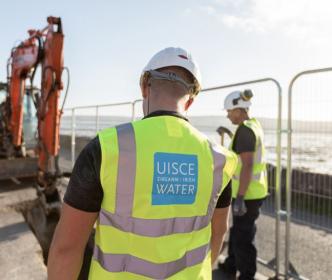 Uisce Éireann workers examining something being dug into the ground 