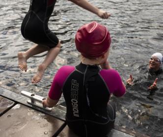 People swimming in the sea by a pier