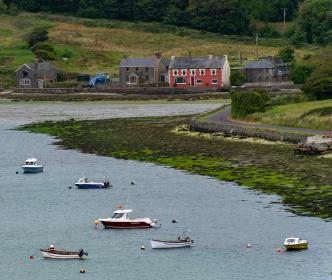 A bay with several small boats and four houses