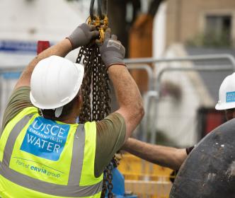 Uisce Éireann workers pulling up blue pipes with chains