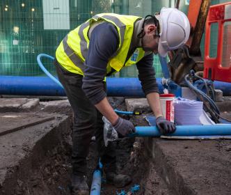 uisce eireann worker repairing pipes in a city 