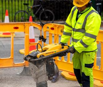 An Uisce Éireann worker drilling the ground on a street