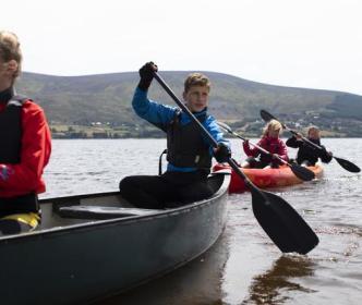 A group of kids canoeing on a lake