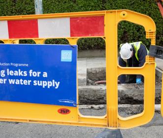 An Uisce Éireann worker fixing a pipe in the ground